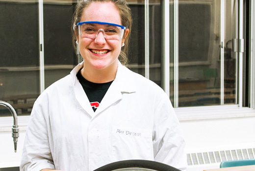 Scientist smiling in the classroom with PPE on