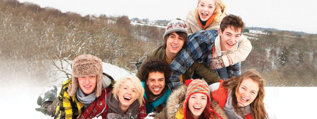 Group of High School Kids lying in the snow smiling