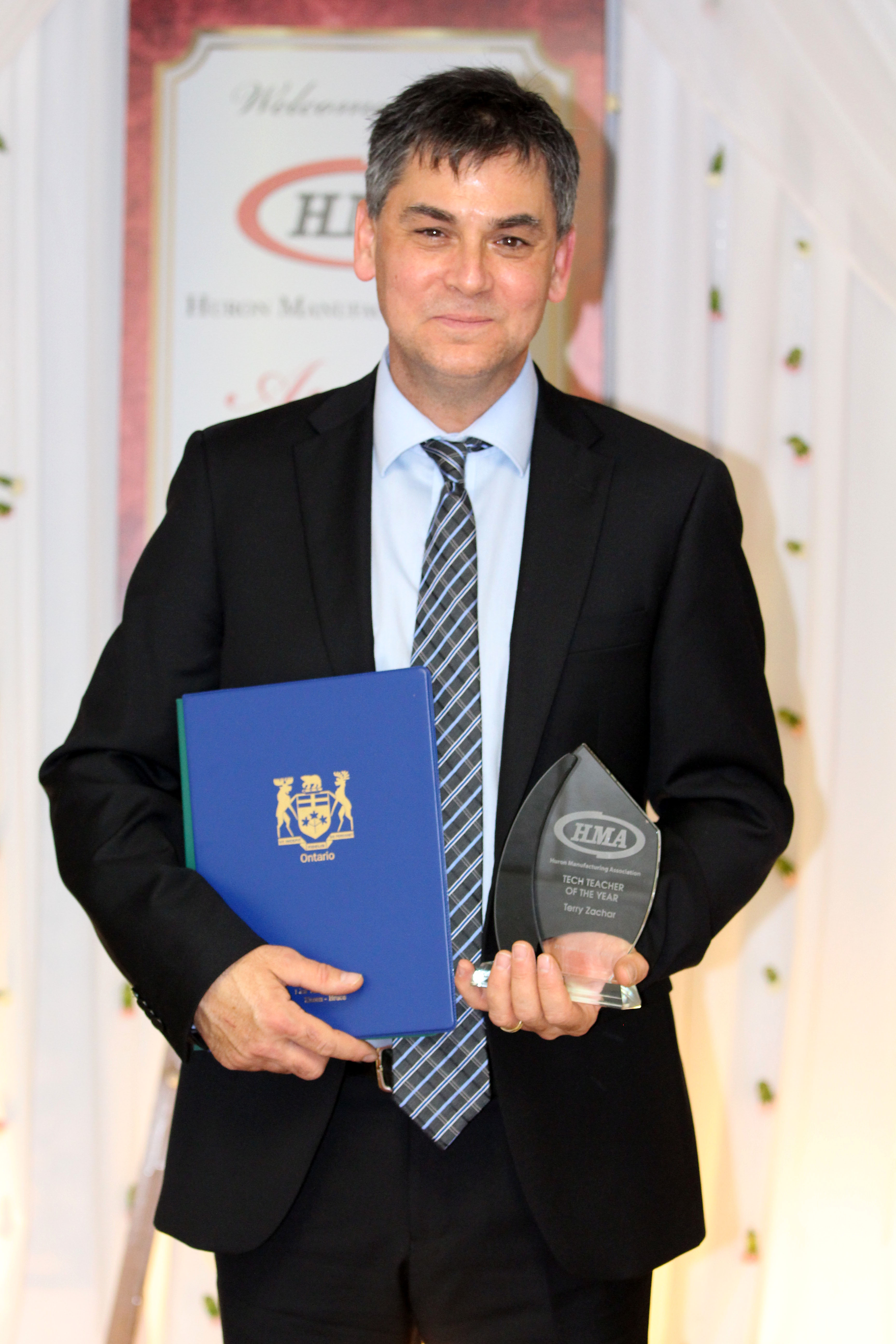 Teacher posing with his award from HMA awards